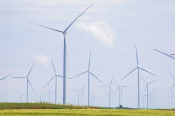 Wind turbines spin gracefully against azure skies; celebrate Global Wind Day, sustainable energy...