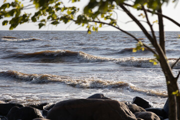 Serene Rocky Shoreline Under Bright Sky with Gentle Waves