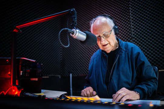 An elderly caucasian man DJs and presents his music show on live radio in Melbourne, Australia