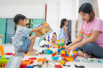 Mom with kids boy and girl learnning build color toy block in classroom