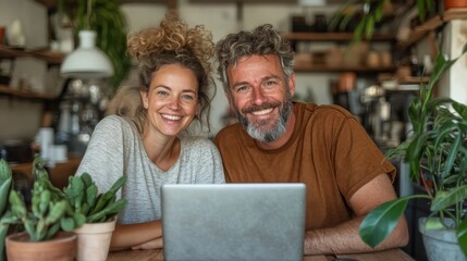 Fototapeta premium This joyful image features a couple smiling and engaging with each other over a laptop at a cozy cafe, capturing warmth, connection, and the enjoyment of shared moments.