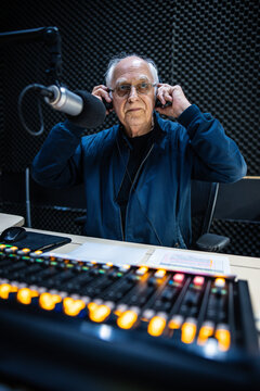 An elderly caucasian man DJs and presents his music show on live radio in Melbourne, Australia