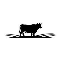 Black silhouette of a cow on a field
