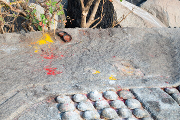Shivalingas, religious place to worship hindu gods in the boulders of Hampi, ritual with color for Holi festival, shore of Tungabhadra river, South India, Karnataka