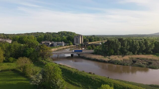 Bunratty castle and surrounding village by a calm river in county clare, aerial view