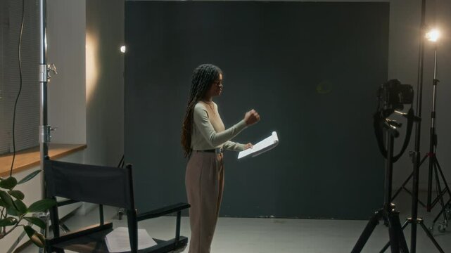 African American actress holding script and rehearsing her performance before filming acting audition in studio