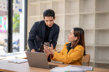 A man and a woman are looking at a cell phone