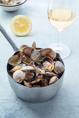 Vongole clams in a saucepan with thyme, lemon, and white wine. Seafood sauce, Mediterranean cuisine