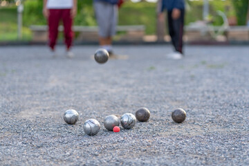 petanque practice on playing field,group of people throwing boules,selective focus at bocce...