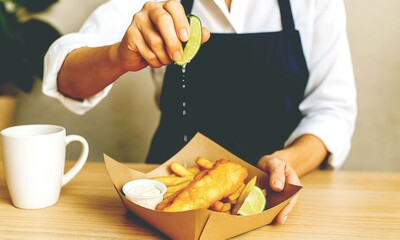 Woman Squeezing Fresh Lime Juice in Takeaway Box on Wooden Table