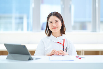 テーブルの前に座る白衣の女性