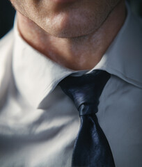 Close-up of businessman wearing elegant blue tie and white shirt	