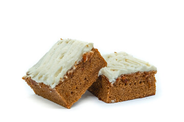 Two pieces of carrot cake drenched in vanilla icing on white background  Natural candy concept.