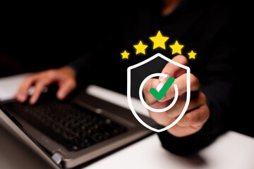 Person interacting with a laptop, highlighting a digital security shield with a green checkmark and...