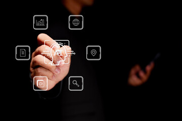 A person interacts with a virtual AI interface displaying various digital icons related to data,...