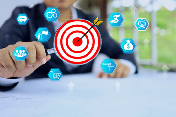 Business target concept with businessman holding a magnifying glass search marketing factor for...