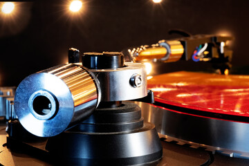 red vinyl record spins on a turntable against a backdrop of flickering lights. A close-up of the...