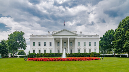 Naklejka premium green lawn, fountain and flowerbed in front of the White House in Washington, DC.