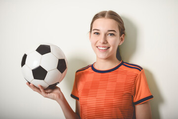 one caucasian young soccer player girl standing in studio gray background