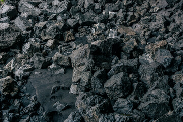 Black volcanic rock texture background. Close up of black volcanic stones.