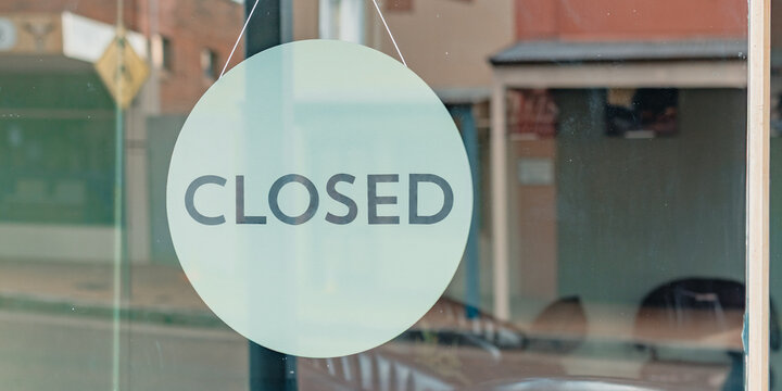 Green closed sign on barber shop window in small rural town