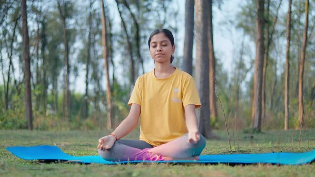 peaceful young woman practicing padmasana yoga in the forest during sunrise. Sukhasana, gyana mudra,