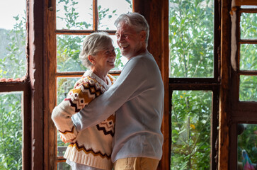 Senior couple in their 70s spending calm and quality time together in a cozy mountain chalet. A...