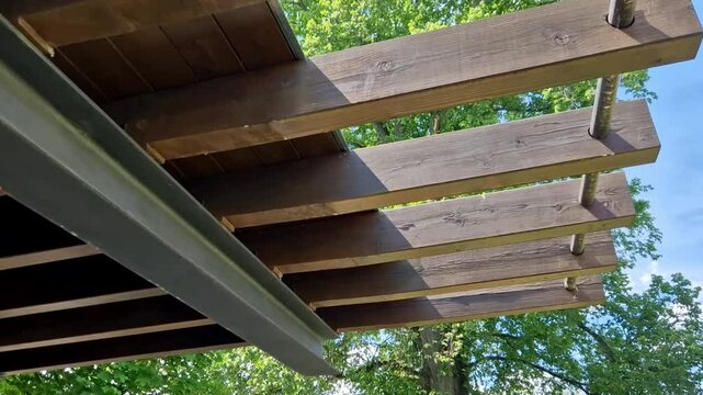 terrace with wooden pergola and plexiglass roof. vines are straining, crawling under the beams. garden or park. sitting with dry wall wine region. restaurant countryside france, truss