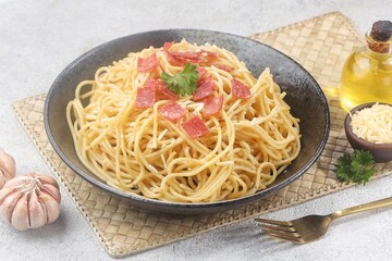 Spaghetti Carbonara is an Italian dish consisting of spaghetti pasta cooked with heavy cream sauce, cheese and meat.