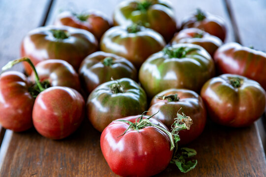 Cherokee Purple tomatoes on wooden table.