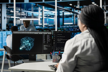 Data center computer scientist at work using machine learning algorithms to analyze datasets....