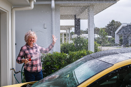 senior woman washing her car