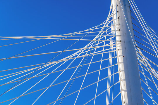 Detailed view of cable-stayed bridge architecture with taut cables under blue sky