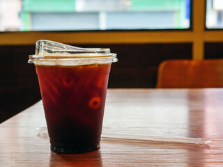 Iced americano black coffee on a wooden desk in coffee shop