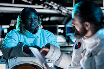 Cosmonauts preparing for planetary mission outside, gathering samples for study. Orbital station talking, beginning landing procedures on solar system planet, deepening understanding of universe