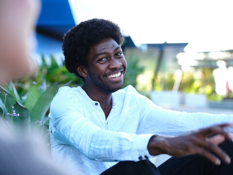 Man smiling outside having a conversation
