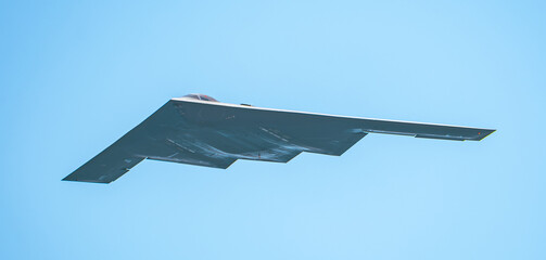 B-2 Spirit Stealth Bomber in Flight Against a Clear Blue Sky