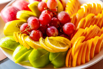 Vibrant Display of Fresh Fruits Arranged Artistically on a Platter During a Summer Gathering