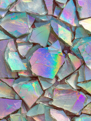 Sparkling pieces of broken iridescent glass create a vibrant and colorful abstract background