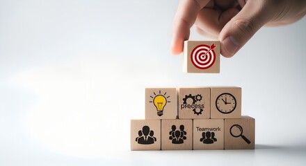 Hand stacking wooden blocks with business icons strategy