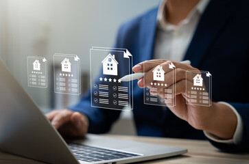 Businessman reviews real estate documents on laptop, Online property management, Digital housing contract, investment planning, Smart organization of real estate transactions using modern tools.