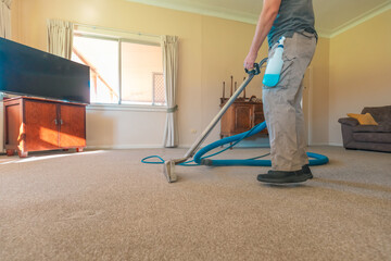 Carpet cleaning professional using steam cleaner in home