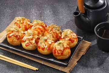 Takoyaki is a typical Japanese snack in the form of small balls made from wheat flour dough and filled with pieces of octopus.