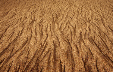 Photo of sand on sea beach with pattern in golden-brown tone, abstract fine art pattern, dreamy...