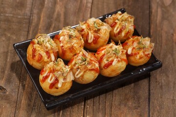 Takoyaki is a typical Japanese snack in the form of small balls made from wheat flour dough and filled with pieces of octopus.