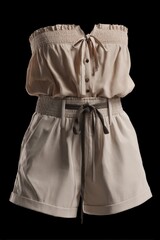 A beige strapless romper with brown buttons and a grey tie belt is displayed against a black backdrop