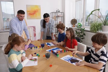 Obraz premium Kids with teachers at painting lesson indoors. Learning to draw