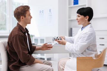 Obraz premium Ophthalmologist consulting young man at white table in clinic