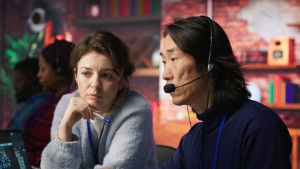 Call center team leader supervising agent helping customers regain access to accounts and devices....