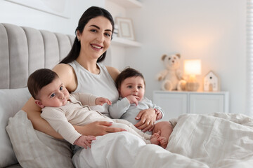 Fototapeta premium Bedtime. Mother with her cute little babies on bed at home